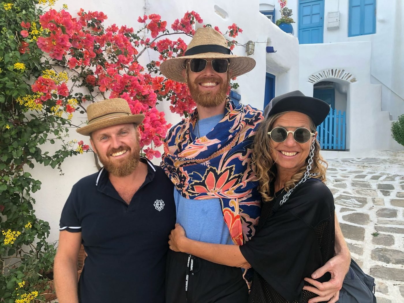 Eric Nielson with two friends in straw hats on a whitewashed lane in the Greek islands