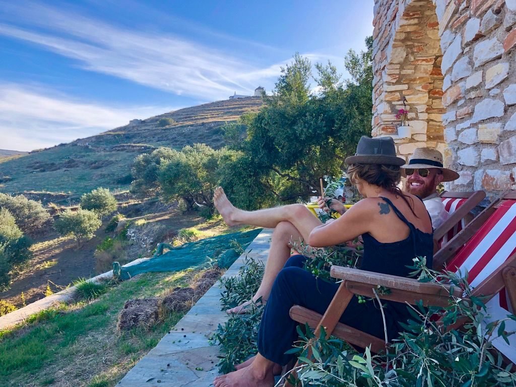 Eric Nielson and a friend picking olives from deck chairs on a Greek hillside