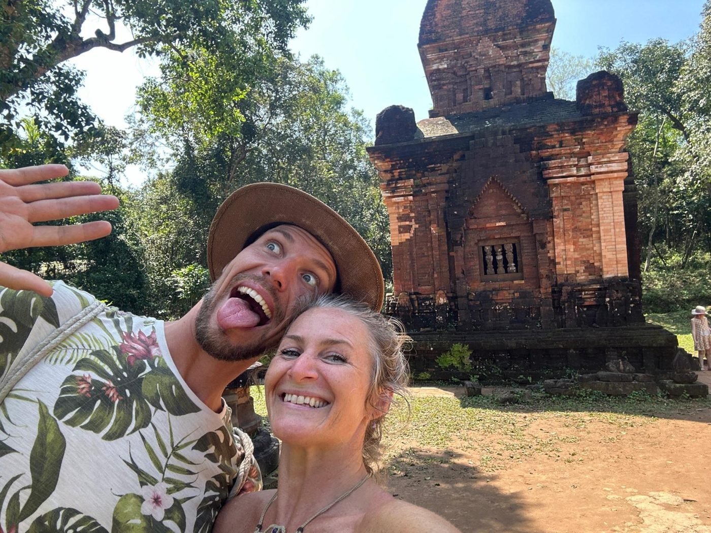 Maya Lila Di Vento laughing in a selfie with a friend before an ancient brick temple in Vietnam
